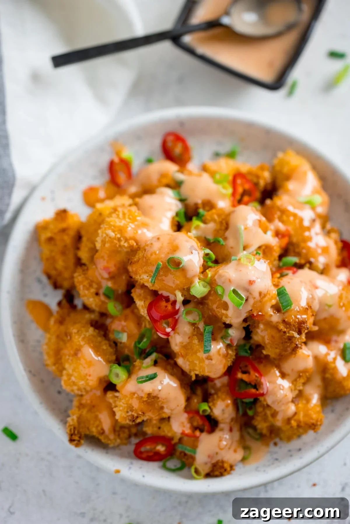 Sichuan Bang Bang Chicken Salad Recipe: Spicy Sesame Chicken 5 White bowl filled with bang bang chicken on a white surface.