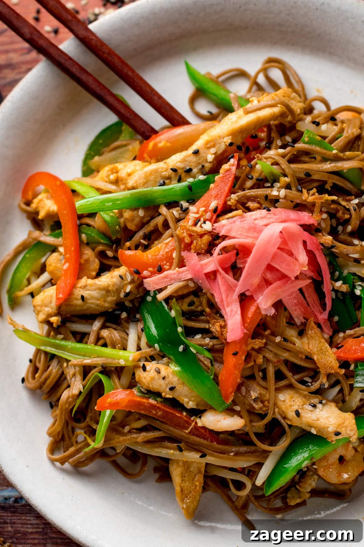 Chicken Yakisoba Recipe: Flavorful Stir-Fried Noodles with Veggies 2 Close up of chicken yakisoba on a white plate with some chopsticks on the side
