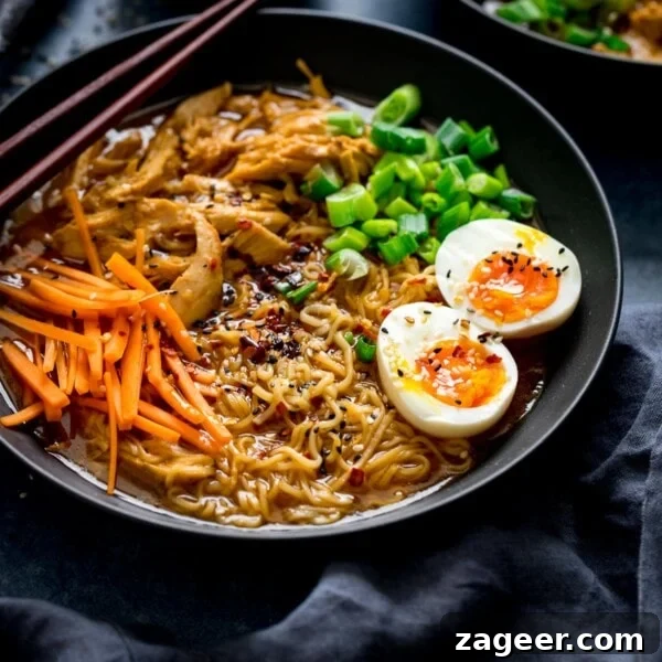 Chicken Yakisoba Recipe: Flavorful Stir-Fried Noodles with Veggies 11 Chicken Ramen in a black bowl topped with egg, carrots and spring onions