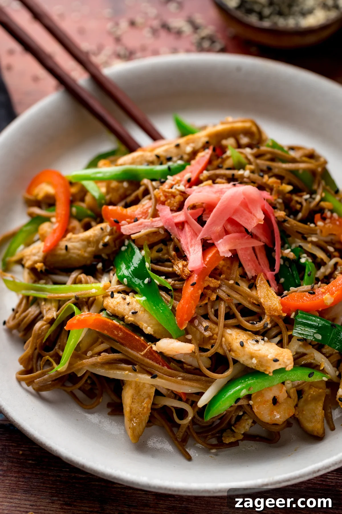 Chicken Yakisoba Recipe: Flavorful Stir-Fried Noodles with Veggies 5 A close up of chicken yakisoba with some chopsticks on a white plate