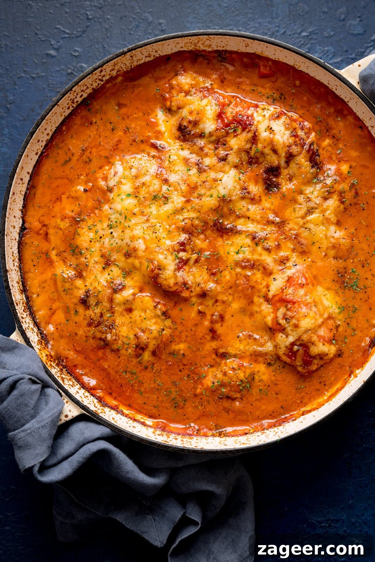 Lasagna-Style Baked Chicken Casserole Recipe 4 Overhead image of lasagne-style chicken bake in a large pan on a blue background.