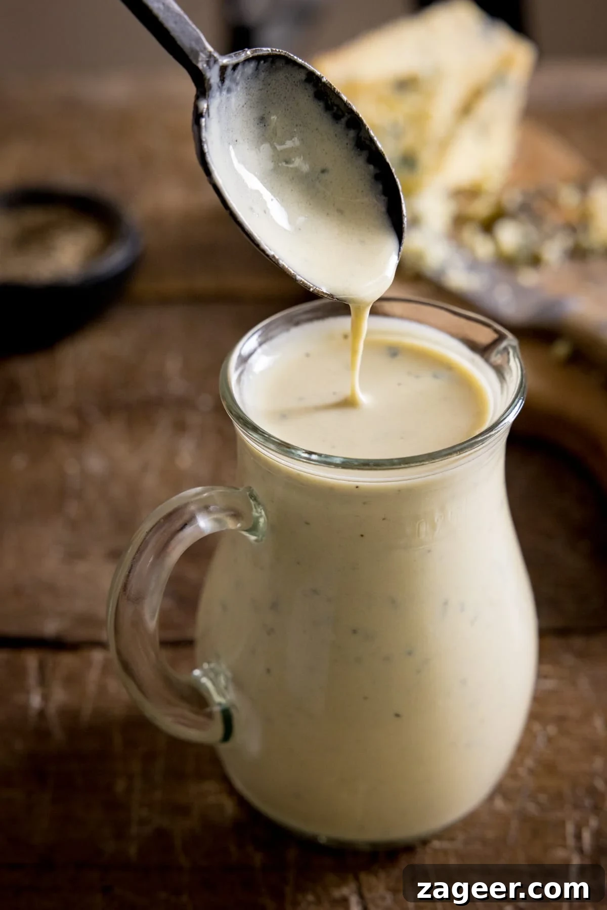 Creamy Blue Cheese Sauce Recipe for Steak and Wings 2 Some blue cheese sauce being spooned into a jug for serving.