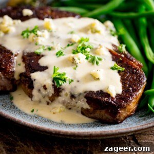 Creamy Blue Cheese Sauce Recipe for Steak and Wings 12 A cooked steak with blue cheese sauce over the top with some green beans, served on a blue plate