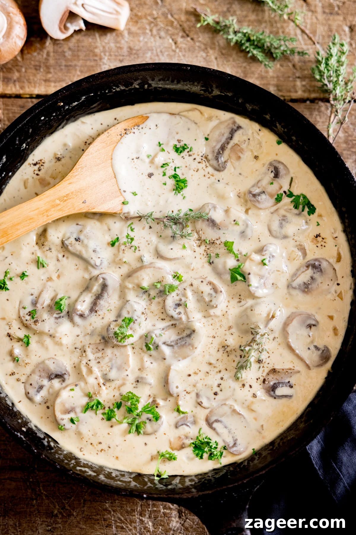 Creamy Mushroom Sauce Recipe for Pasta, Steak & Chicken 5 A pan of creamy mushroom sauce with a wooden spoon in it