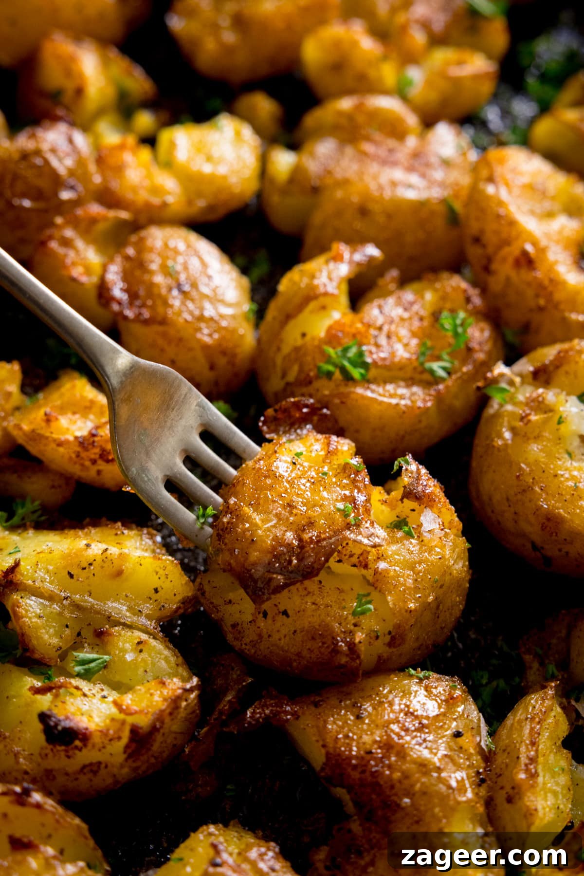 Crispy Garlic Smashed Potatoes Recipe for Perfectly Crispy Skins 6 A plate of crispy smashed potatoes with a fork digging into a potato