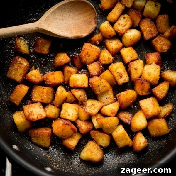 Perfect Baked Potato: Tips, Timing, and Crispy Skin Tricks 21 Square image of saute potatoes in a pan with a wooden spoon
