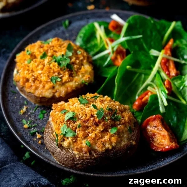 Creamy Garlic and Mushroom Stuffed Bread Rolls 6 Square image of Stuffed mushrooms on a black plate with salad
