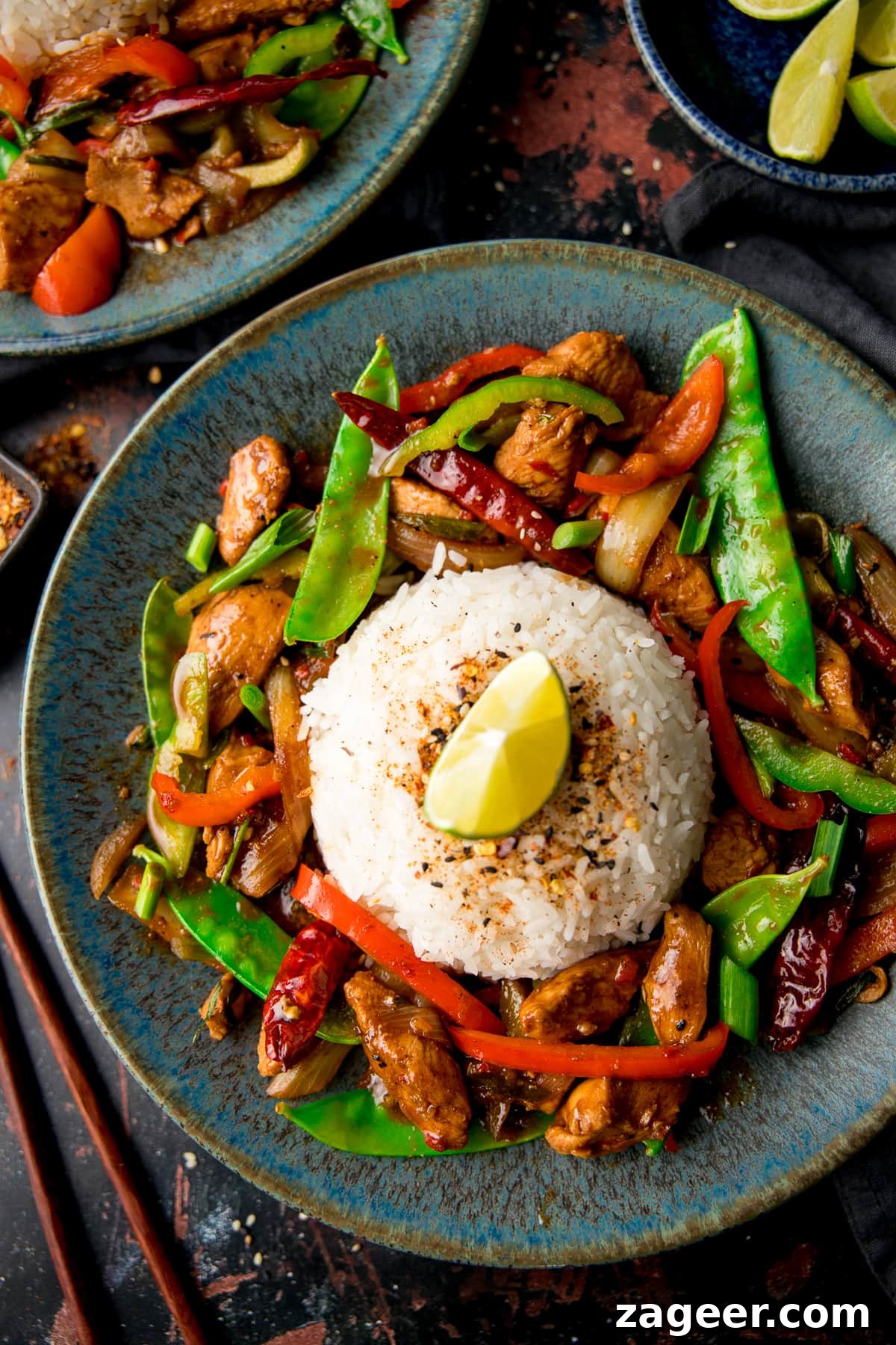 Spicy Firecracker Chicken Recipe with Crispy Bites 2 Firecracker chicken stir fry surrounding a mound of rice on a blue plate