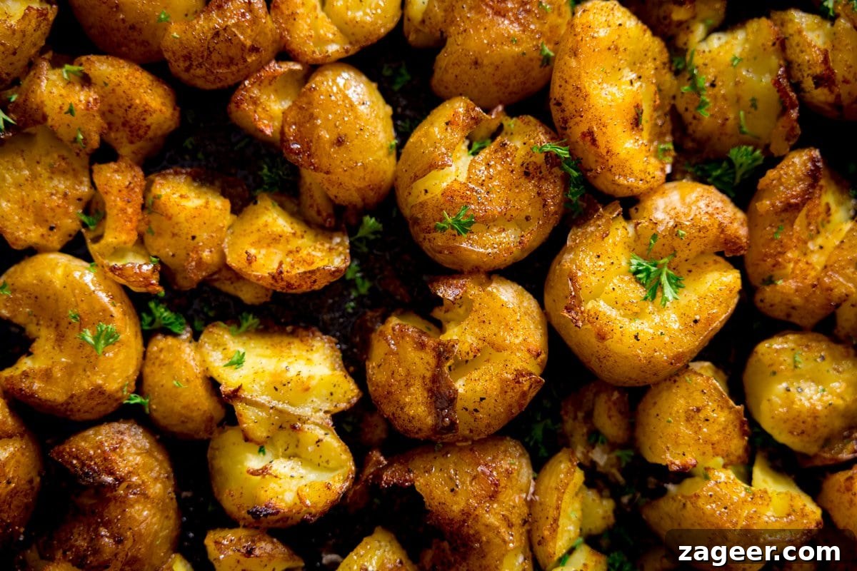 A close up photo of crispy smashed potatoes sprinkled with parsley