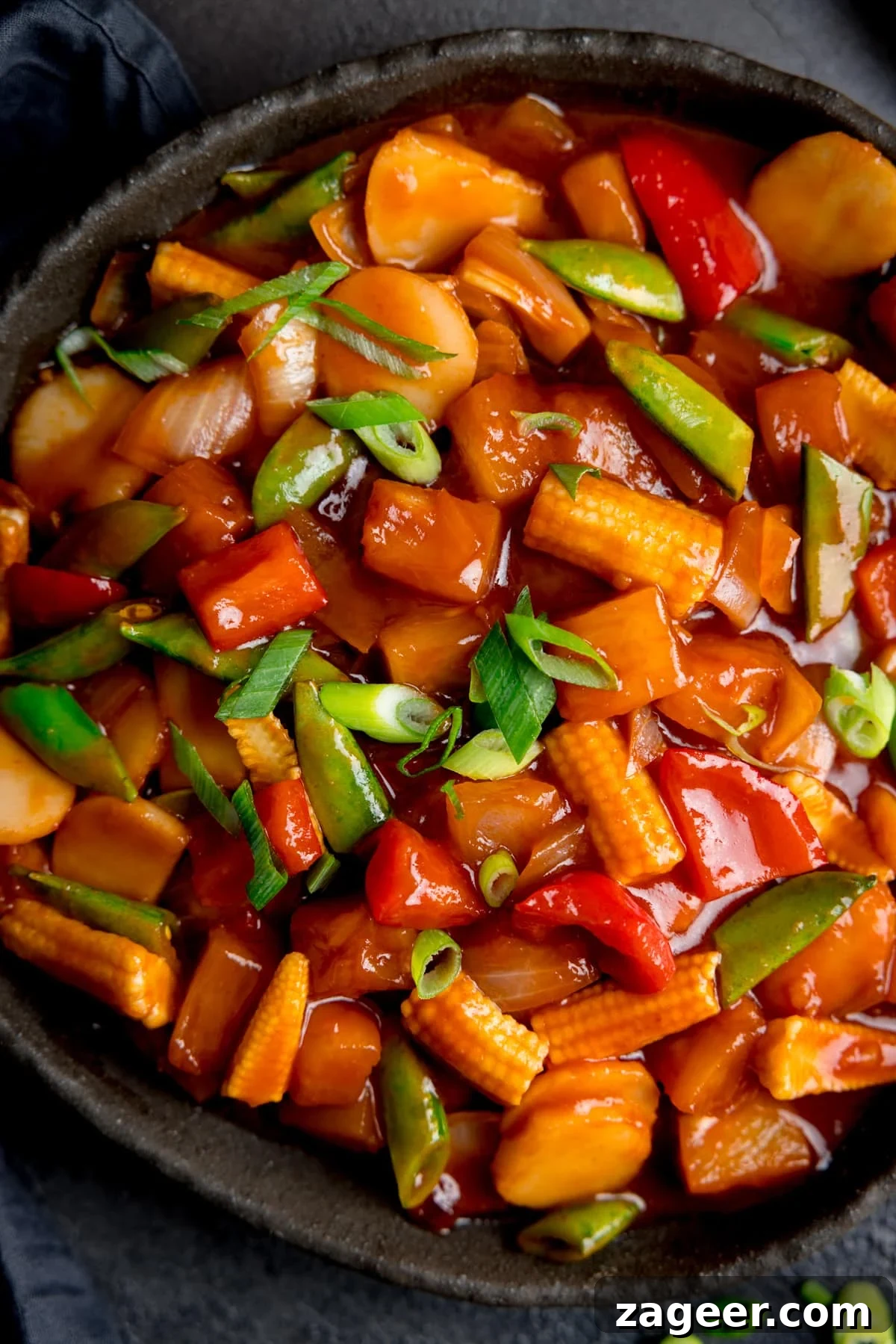 Sweet and Sour Vegetable Stir-Fry Recipe for Tangy Flavor 5 Close up overhead shot of sweet and sour vegetables in a black serving bowl.