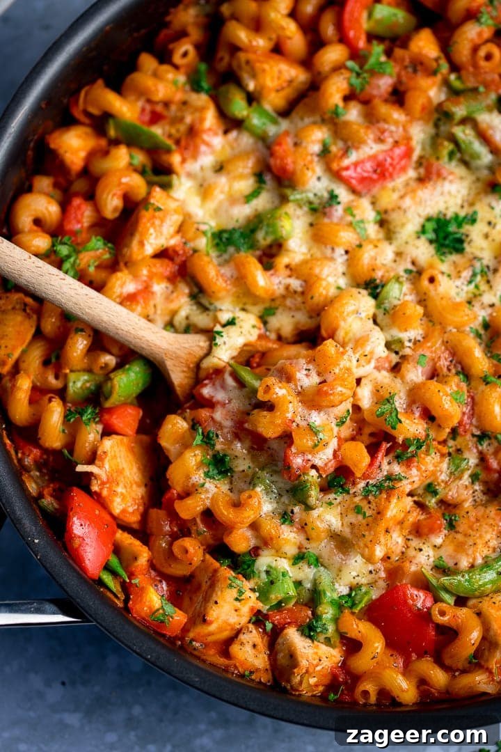 30-Minute One-Pot Chicken Pasta Recipe for Busy Weeknights 2 Close up of one pot chicken pasta with a wooden spoon in the pan