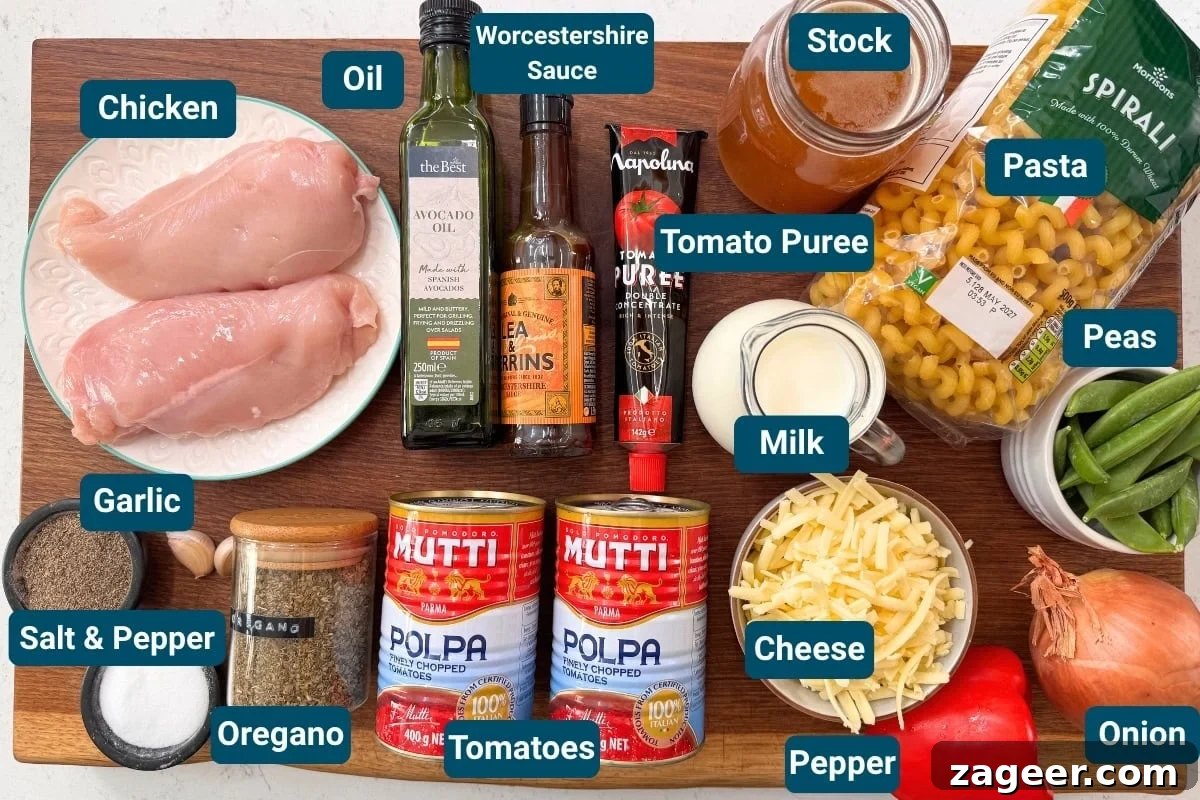 30-Minute One-Pot Chicken Pasta Recipe for Busy Weeknights 4 A wooden board with raw chicken fillets, tinned tomatoes, cheese, pasta, milk, tomato purée, oil, peas, stock, garlic, onion, spices and sauces for a one pot chicken pasta.
