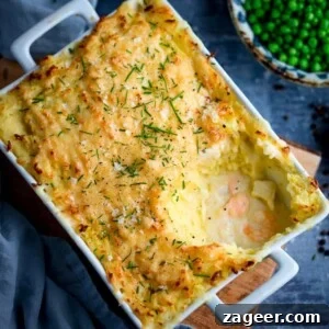 Fish pie with mashed potato in a white rectangular dish - scoop taken out