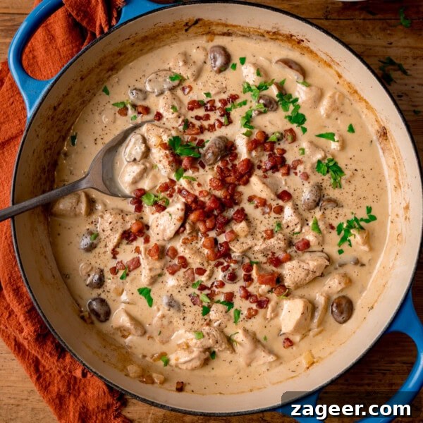 Classic Chicken Cacciatore Recipe: Rustic Italian Hunter’s Chicken 13 A blue cast iron pan filled with chicken in a cream-cider sauce.