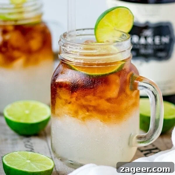 Homemade Mulled Cider Recipe for Cozy Fall Nights 8 Mason jar glass filled with dark and stormy cocktail, topped with a slice of lime