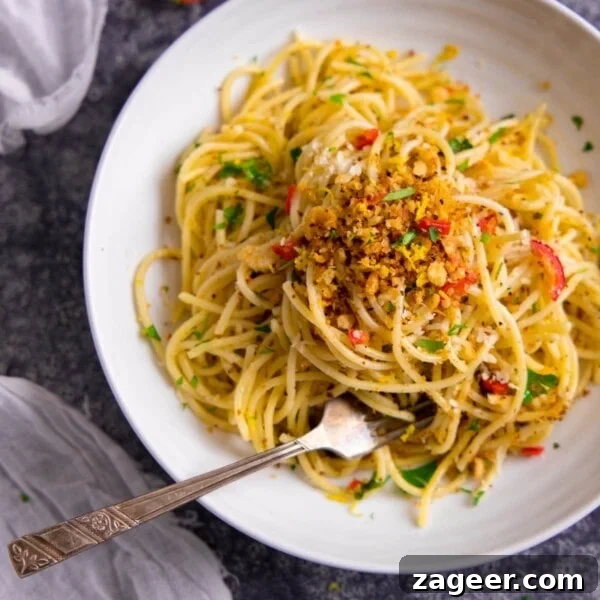 Roasted Veggie Pasta with Garlic and Parmesan 14 Spaghetti with garlic breadcrumbs and red chilli on a white plate.