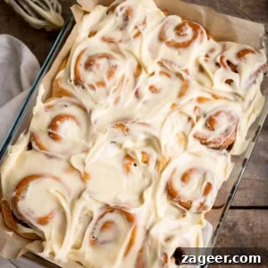 Fluffy Cinnamon Rolls Recipe for Soft, Homemade Swirls 14 Overhead square image of 12 cinnamon rolls in a baking dish, topped with cream cheese frosting.