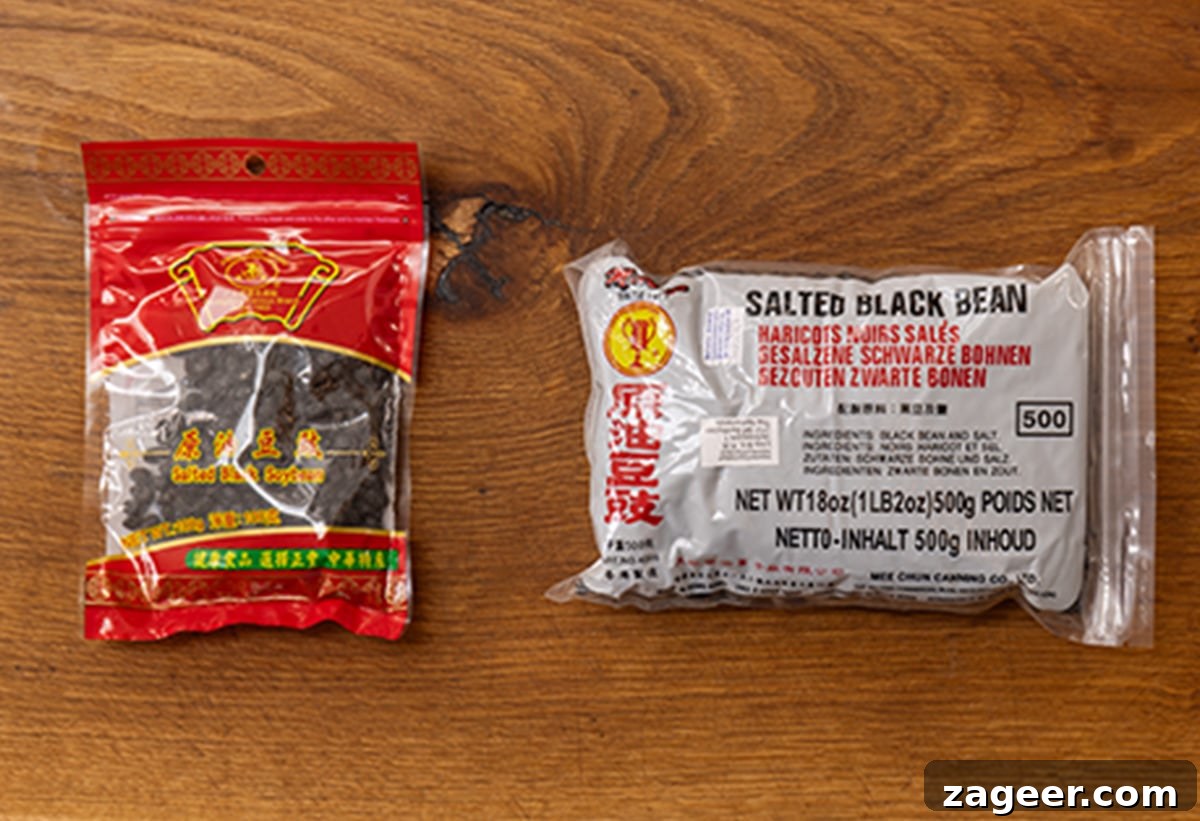 Authentic Black Bean Sauce Recipe for Stir-Fries and Marinades 5 two different packets of fermented black beans on a wooden board.