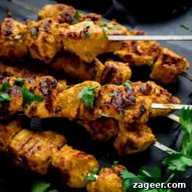 chicken tikka skewers on a dark background