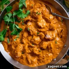 Butter Chicken in a pan with fresh coriander.