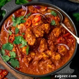 chicken madras in a serving bowl topped with chilles and coriander