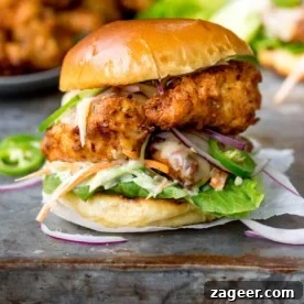 Square image of Crispy chicken burger on a brioche bun with lettuce.