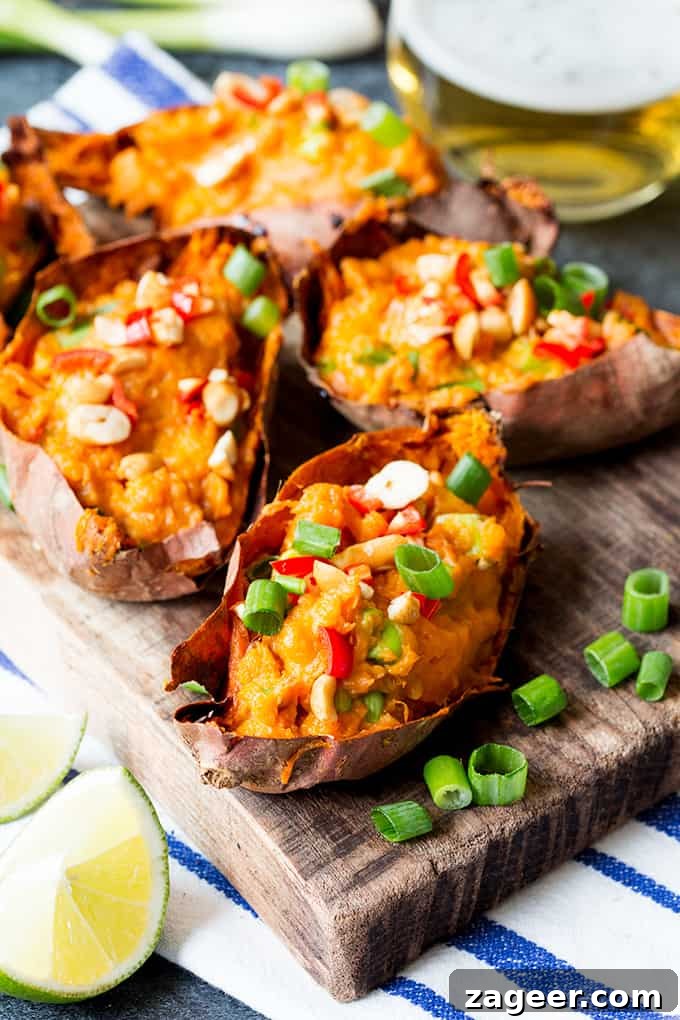 Crispy Thai-Style Sweet Potato Skins with Spicy Peanut Dip 2 Thai-inspired sweet potato skins on a wooden board, topped with spring onions, chillies and peanuts.