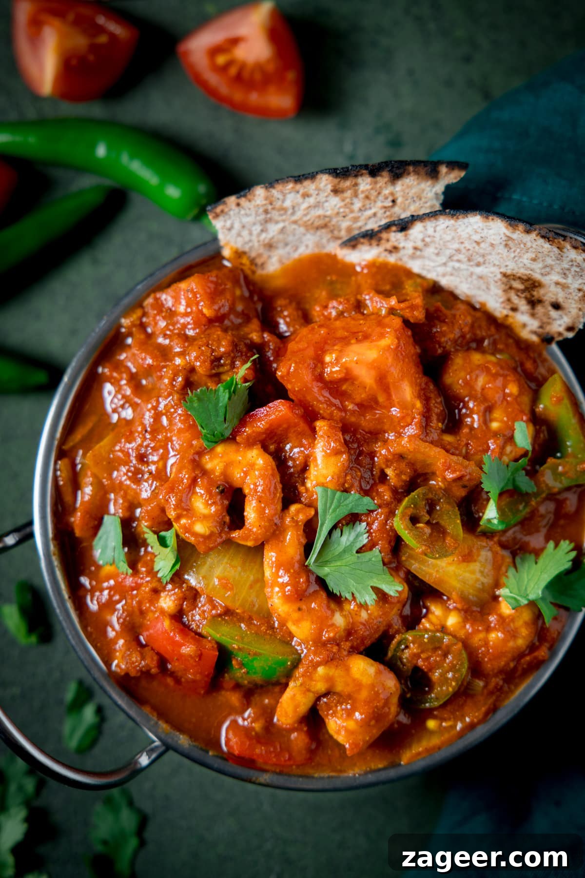Prawn Balti Curry Recipe: Flavorful Indian-Style Shrimp Curry 2 Close up picture of a prawn balti in a balti dish on a green background.