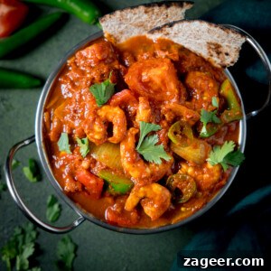 Prawn Balti Curry Recipe: Flavorful Indian-Style Shrimp Curry 9 Overhead close up picture of a prawn balti curry in a balti dish on a green background.
