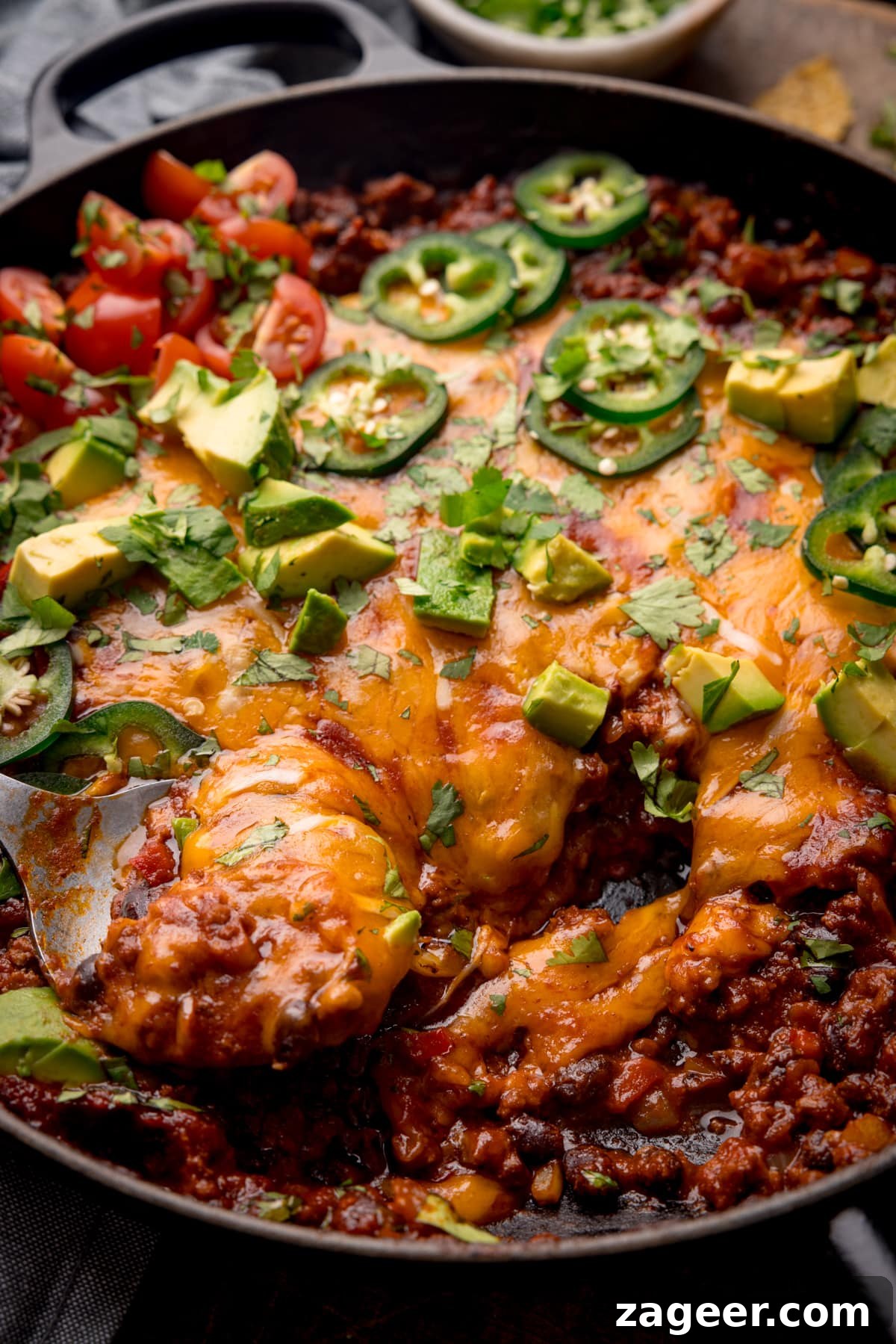 Tex‑Mex Minced Beef Recipe: Flavorful Beef for Tacos & Bowls 5 A close-up shot of Tex-Mex minced beef in a black cast iron pan with cheese, jalapenos, coriander and avocados on top.