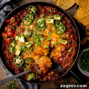 Tex‑Mex Minced Beef Recipe: Flavorful Beef for Tacos & Bowls 8 Tex-Mex minced beef in a black cast iron pan with cheese, jalapenos, coriander and avocados on top.