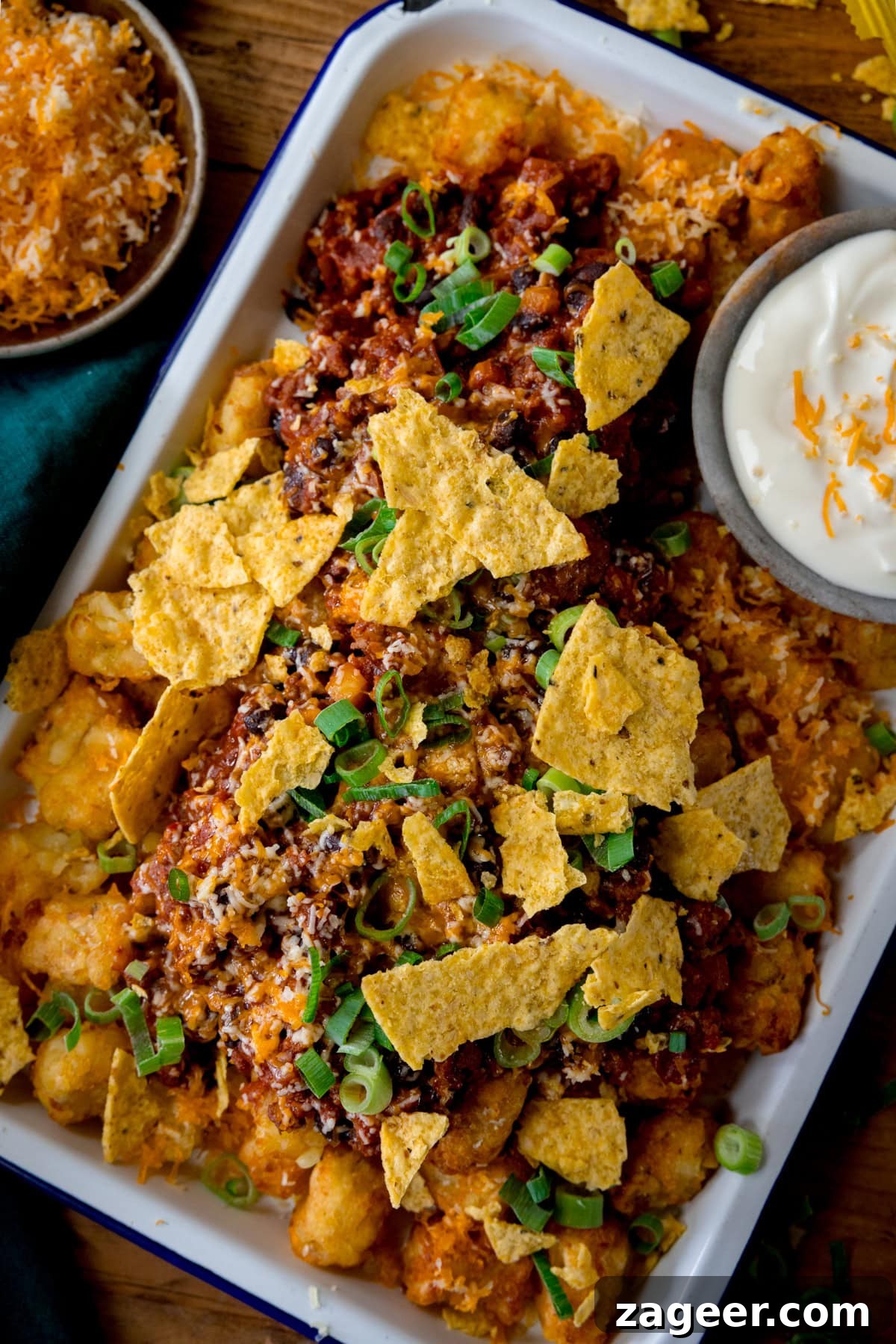 Loaded Totchos: Crispy Hash Brown Bites with Cheesy Toppings 2 A tall image of loaded Tochos, which are topped with