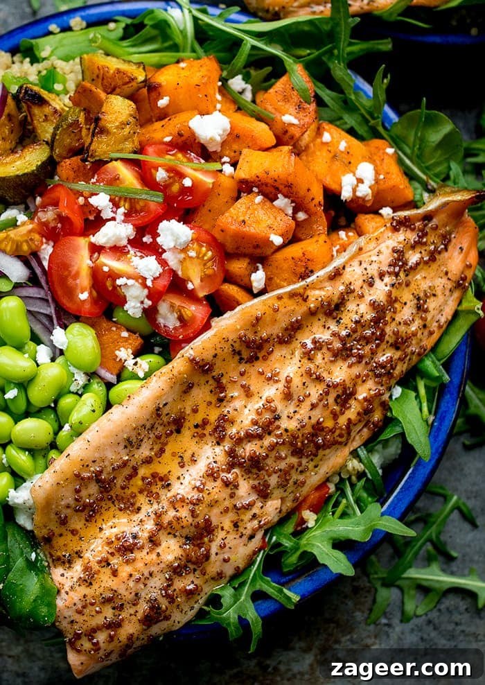 Honey Mustard Trout with Quinoa, Roasted Veggies & Feta 4 Close up image of salad bowl filled with roasted veg, tomatoes, edamame, red onion, courgette and topped with honey mustard trout.