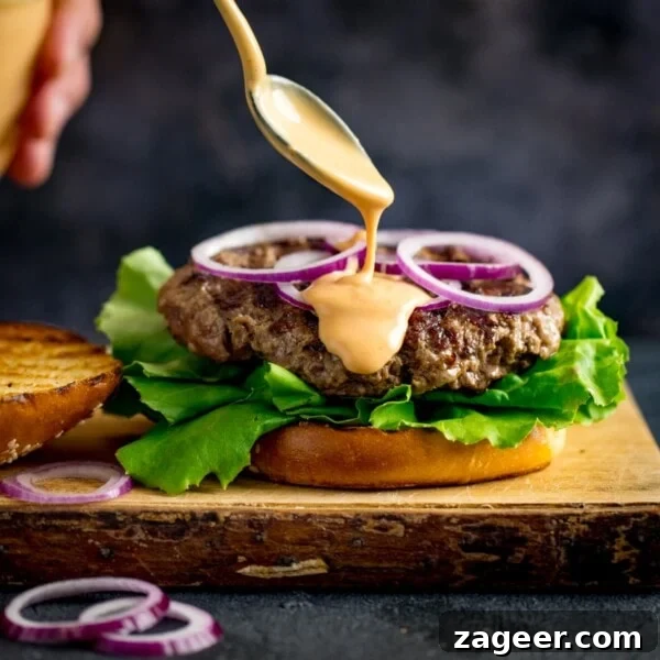 Authentic Caesar Salad Dressing Recipe You Can Make at Home 10 Burger sauce being drizzled from a spoon onto an open burger