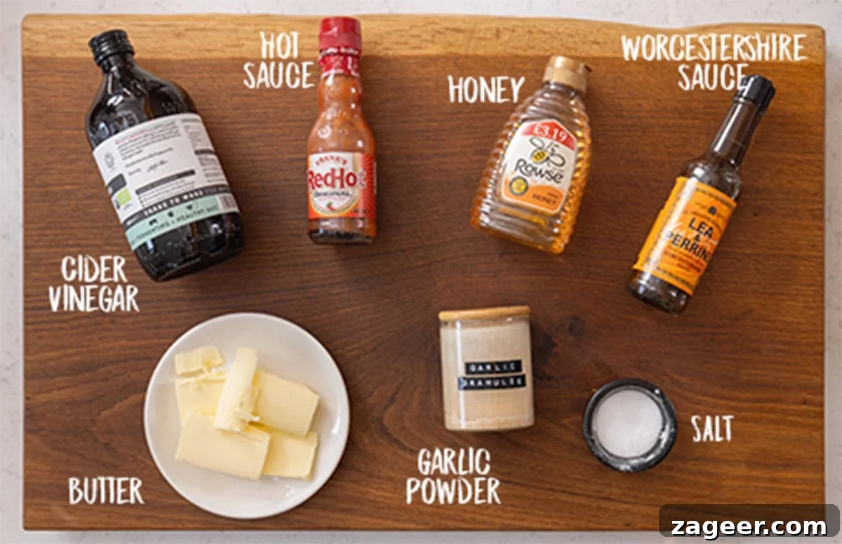 A wide, overhead shot of the ingredients for Buffalo Sauce. The ingredients are placed on top of a wooden cutting board.