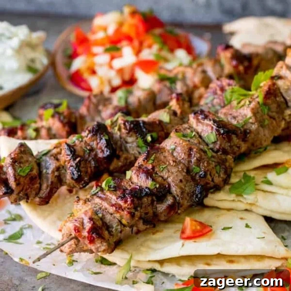 Square image of Lamb souvlaki kebabs on top of toasted breads
