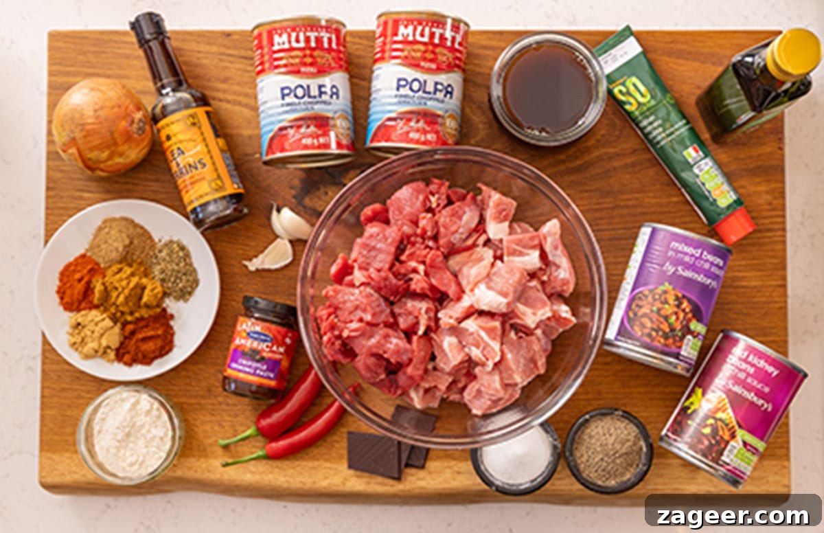 Slow-Cooked Pork and Beef Chili Recipe for Tender, Flavorful Meals 4 Ingredients for slow cooker pork and beef chilli on a wooden board.