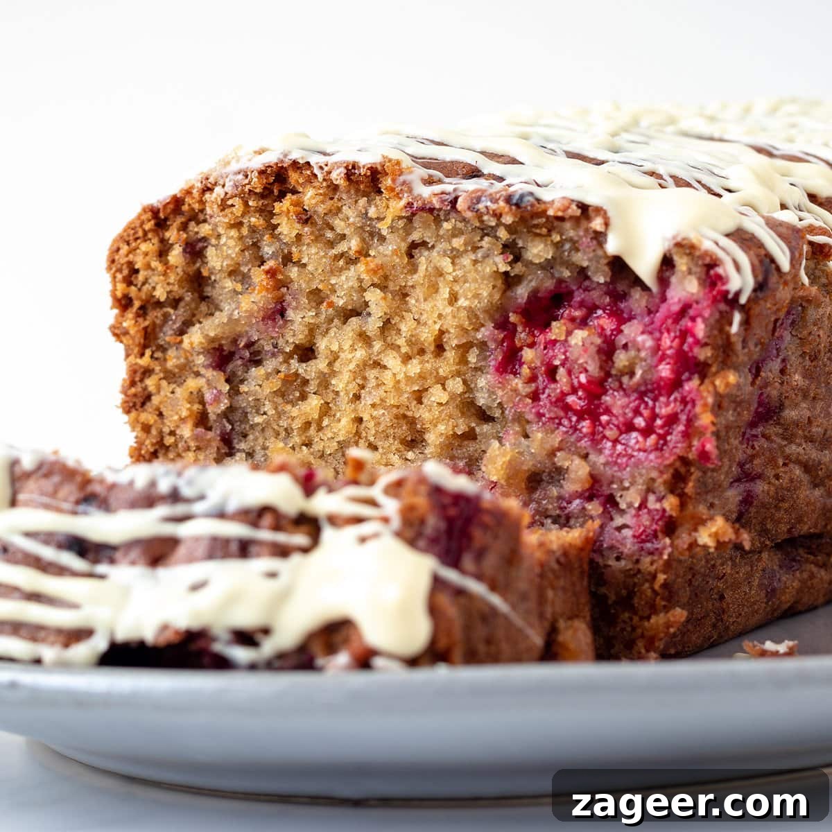 Raspberry White Chocolate Loaf Cake Recipe for Moist Dessert 9 A close up picture of a raspberry and white chocolate cake showing the internal fluffy texture of the cake.