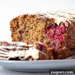 Raspberry White Chocolate Loaf Cake Recipe for Moist Dessert 10 close up picture of a raspberry and white chocolate cake showing the internal fluffy texture of the cake.