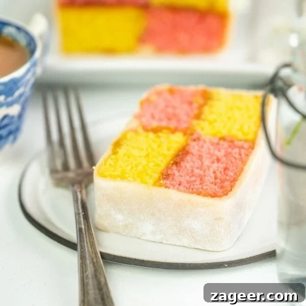 Raspberry White Chocolate Loaf Cake Recipe for Moist Dessert 7 Battenberg cake slice on a plate with a fork on a light background.