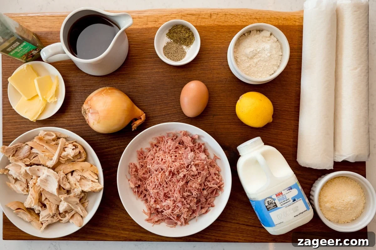 Savory Chicken and Ham Pie Recipe with Flaky Crust 3 A wide, overhead shot of the ingredients for chicken and ham pie. The ingredients are laid out on a wooden cutting board, which is on top of a white marble surface. The ingredients are as follows: pastry, oil, unsalted butter, onion, flour, strong chicken stock, whole milk, lemon, dried thyme, black pepper, parmesan, shredded chicken, shredded ham, and an egg.
