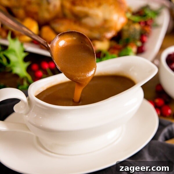 Make-Ahead Bacon Mashed Potato Casserole for Holiday Meals 6 Christmas gravy being poured off a spoon into a white gravy boat