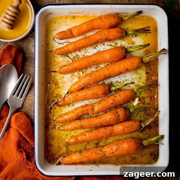 Make-Ahead Bacon Mashed Potato Casserole for Holiday Meals 7 A square, overhead shot of Honey Roasted Carrots in a white tray.