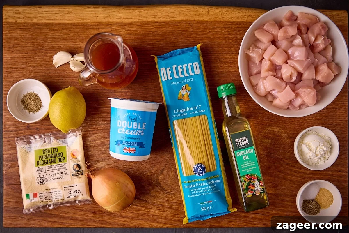 Overhead photo of individual ingredients for making garlic parmesan chicken pasta on a wooden board.