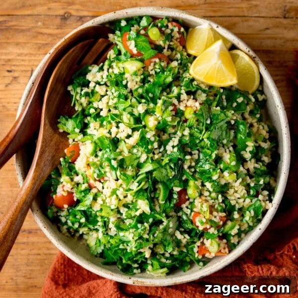 Crispy Lamb Salad with Lemon Mint Dressing 14 A bowl of tabbouleh salad with bulgur, parsley, tomatoes, and lemon wedges.