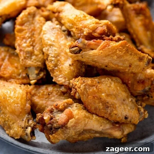 Crispy Garlic Parmesan Chicken Wings Recipe 14 Close up image of crispy chicken wings piled up on a grey plate.