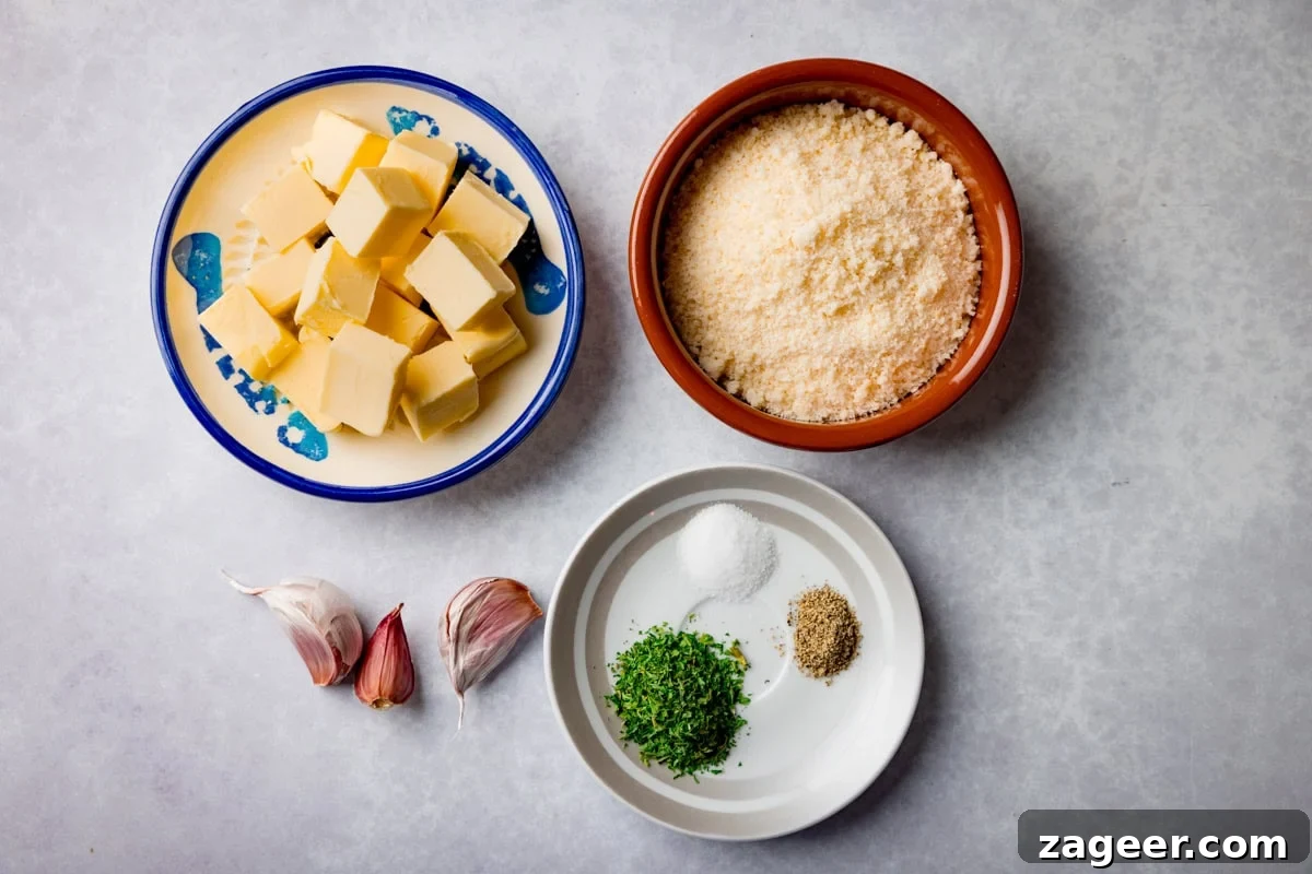 Crispy Garlic Parmesan Chicken Wings Recipe 4 A wide, overhead shot of the ingredients for Garlic Parmesan Chicken Wings. They are laid out on a light grey surface, they are as follows: chicken wings, baking powder, butter, garlic, parmesan, parsley, salt, and pepper.