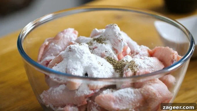 Crispy Garlic Parmesan Chicken Wings Recipe 7 Raw chicken wings in a bowl with baking powder and seasoning