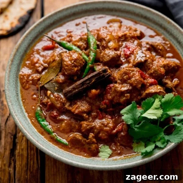 Authentic Lamb Rogan Josh Recipe: Flavorful Kashmiri Curry 9 Lamb Bhuna curry in a green bowl on a wooden table
