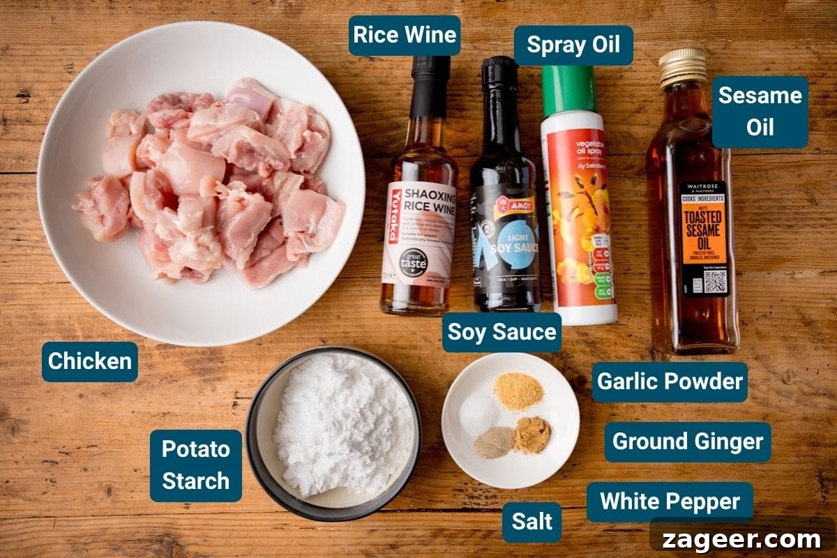 Crispy Air Fryer Chicken Karaage Recipe for Authentic Japanese Flavor 3 A bowl of raw chicken, potato starch, seasonings, and sauces sits on a wooden surface.